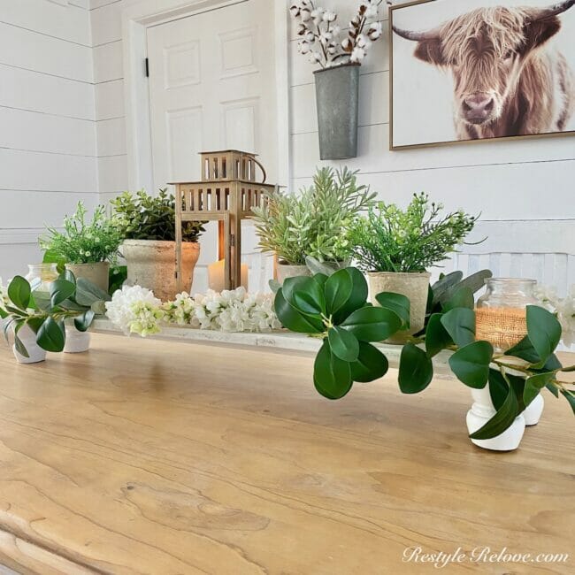 white table riser with greenery and candles