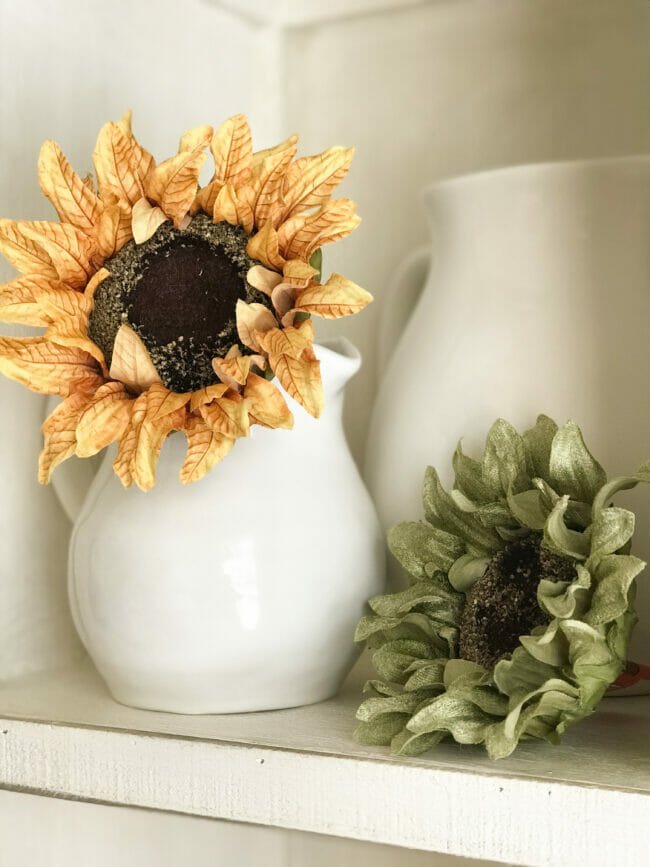 Gold and green sunflowers in white pitcher