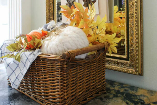 yarn pumpkin and leaves sitting in basket 
