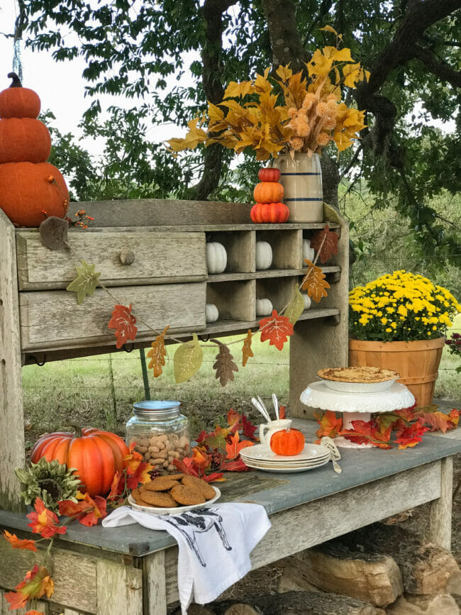 old potting table with fall decor and food