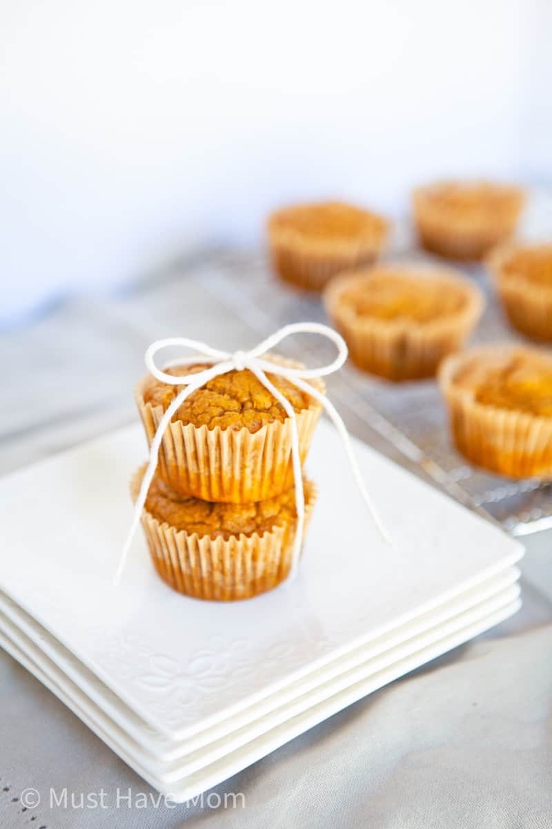 pumpkin muffins on white dishes tied with string
