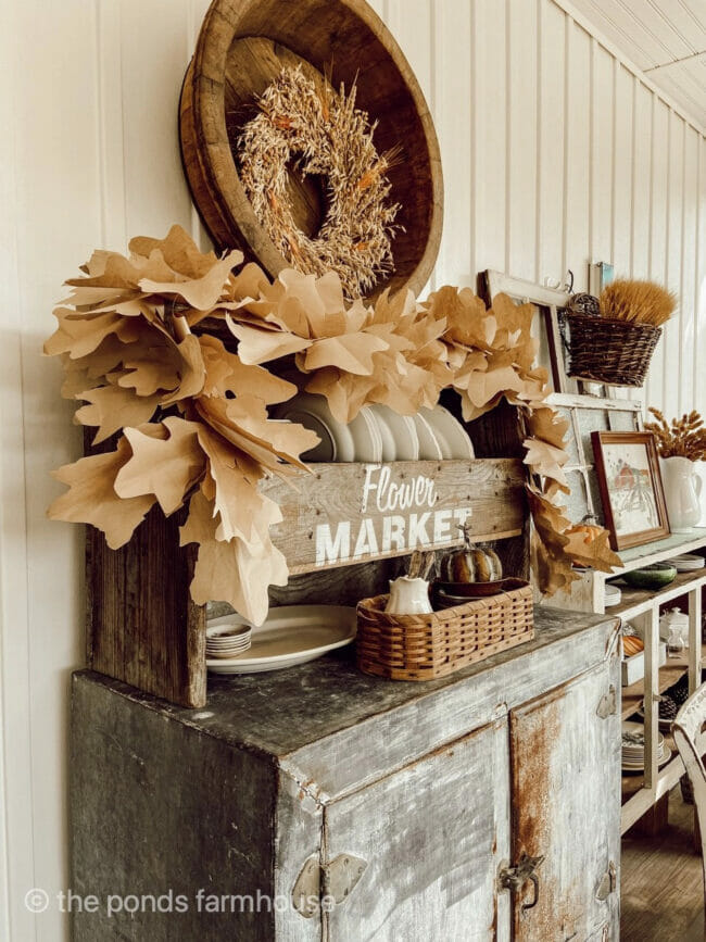 vintage cupboard, plates and accessories with paper made leaf garland