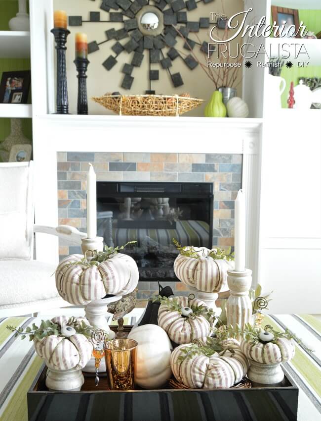 ticking fabric pumpkins on a tray in front of a mantel