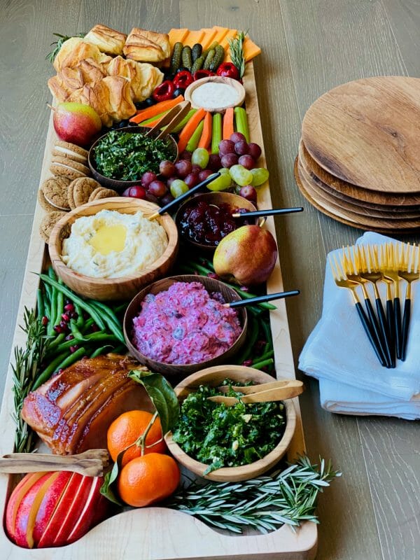 board with meat, potatoes, green beans, carrots and fruit