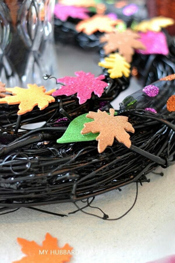 black wreath with bright leaf cutouts sitting on top