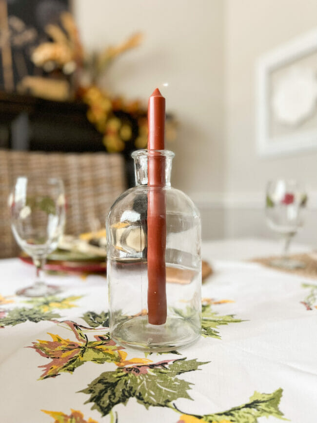 rust candlestick in clear bottle
