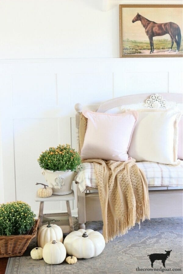 entryway bench with pink pillow and fall mums