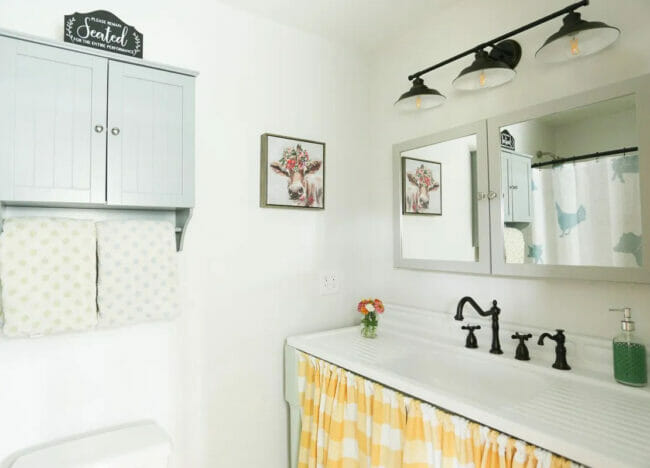 bathroom with yellow and white curtain at sink