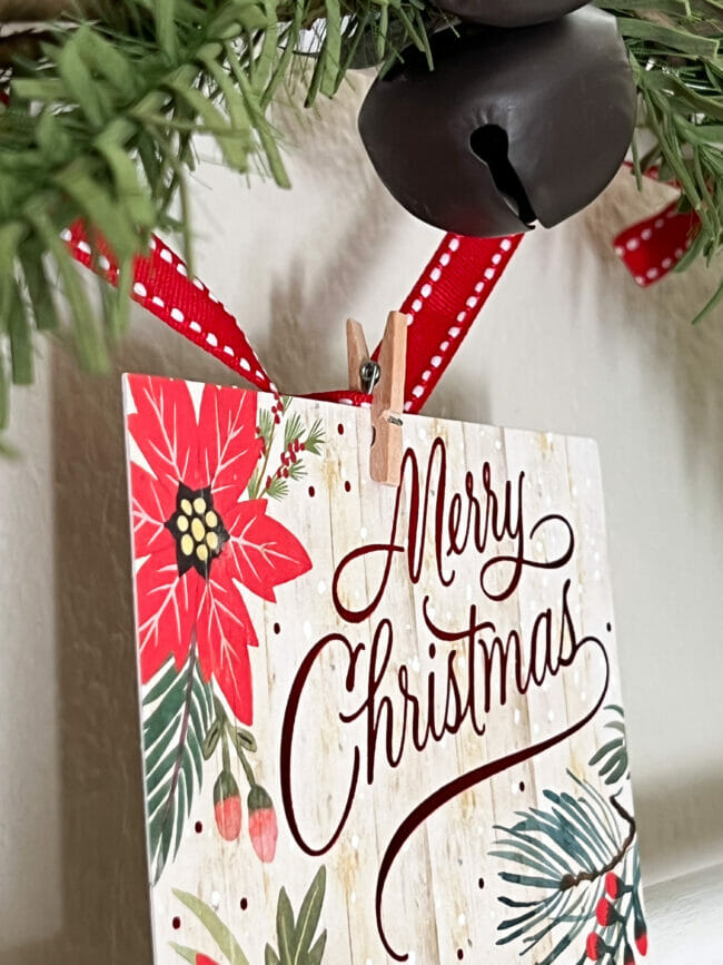 close up of a Christmas card clipped on a red ribbon