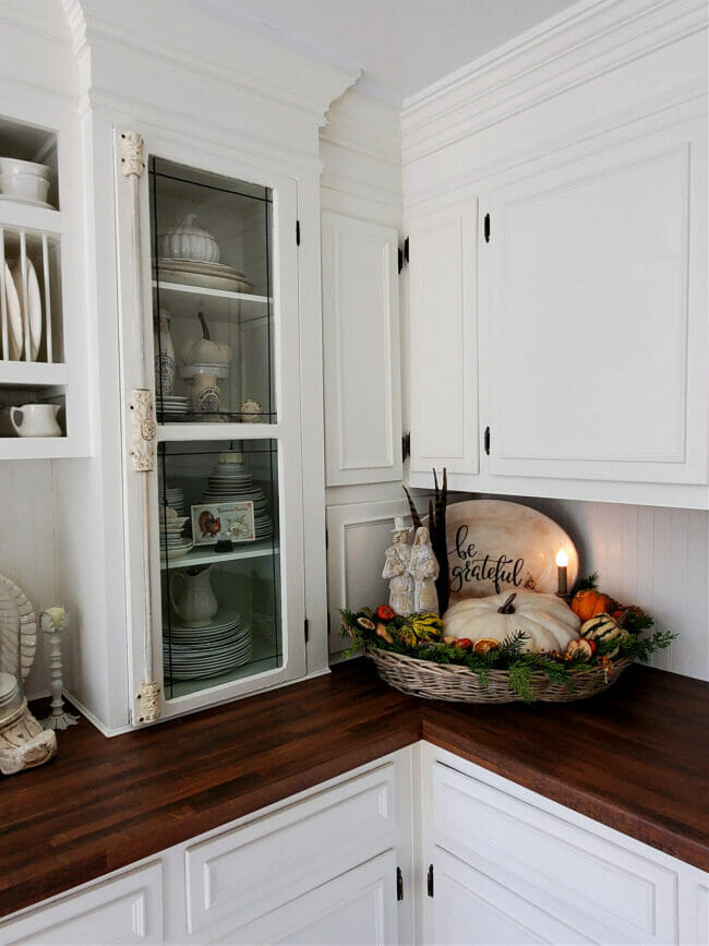 white kitchen with pilgrims in fall basket