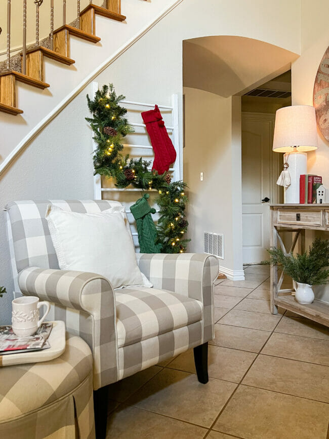 gray and white checked chair with ladder and garland with stocking
