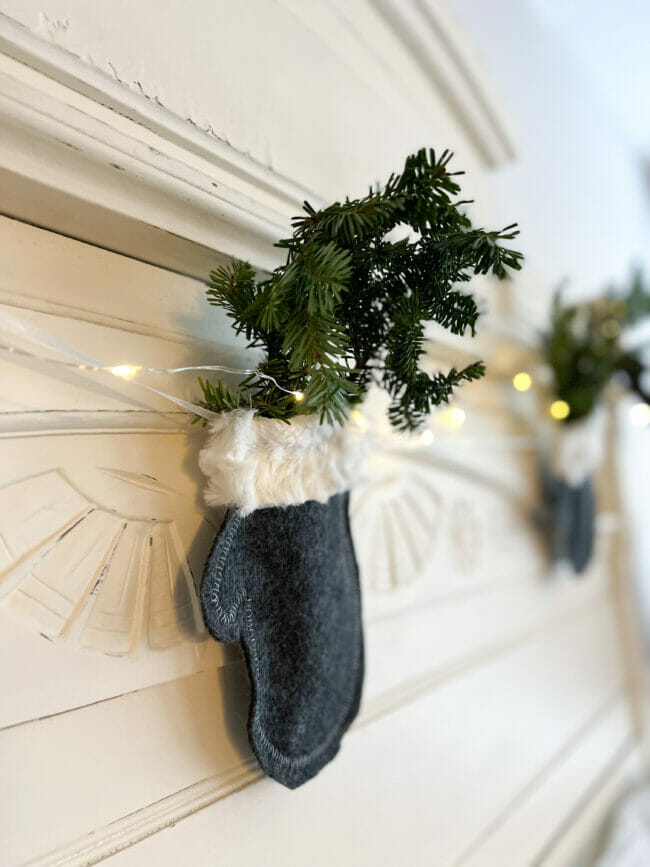 Gray and white felt mitten garland with fresh greens inside