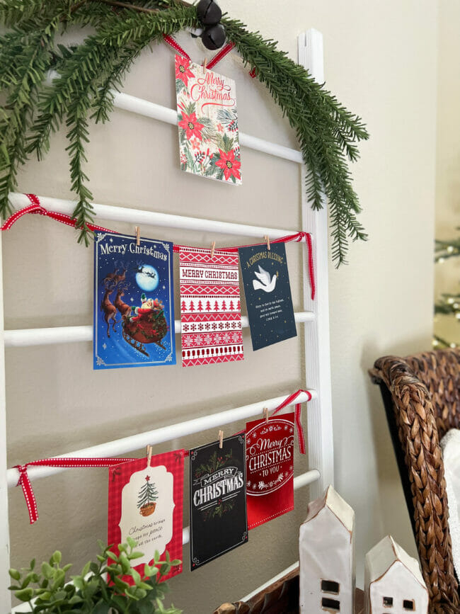 Close up of white ladder with Christmas cards clipped on ribbon