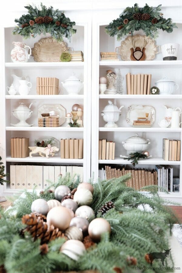 bookcases decorated for Christmas with balls and greenery