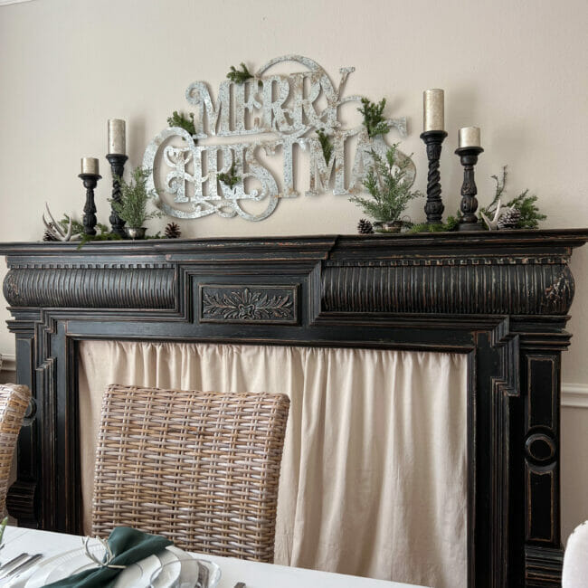 Black mantel with large Merry Christmas sign and candles
