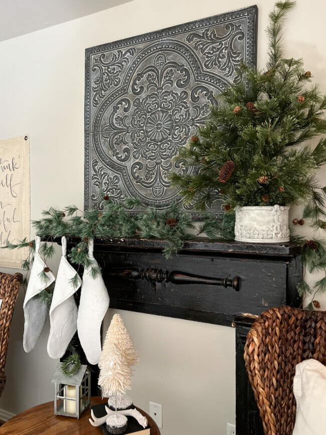 black mantel with white stockings and greenery