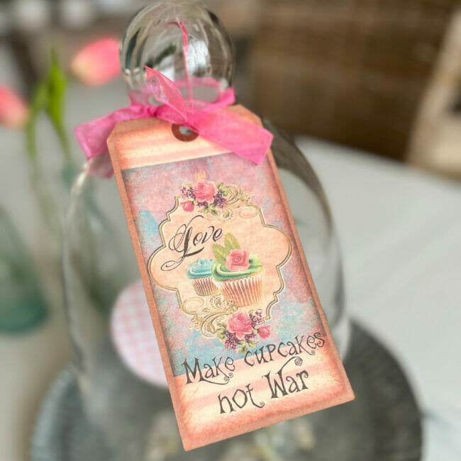 make cupcakes not war tag hanging on cloche