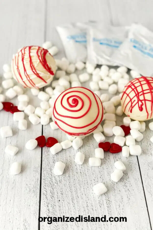red and white cocoa boms with mini marshmallows