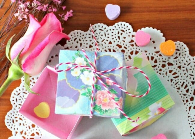 brightly colored boxes tied with string with rose and candy around it