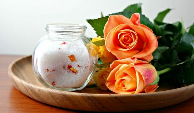 peach roses with bath salts on wooden tray