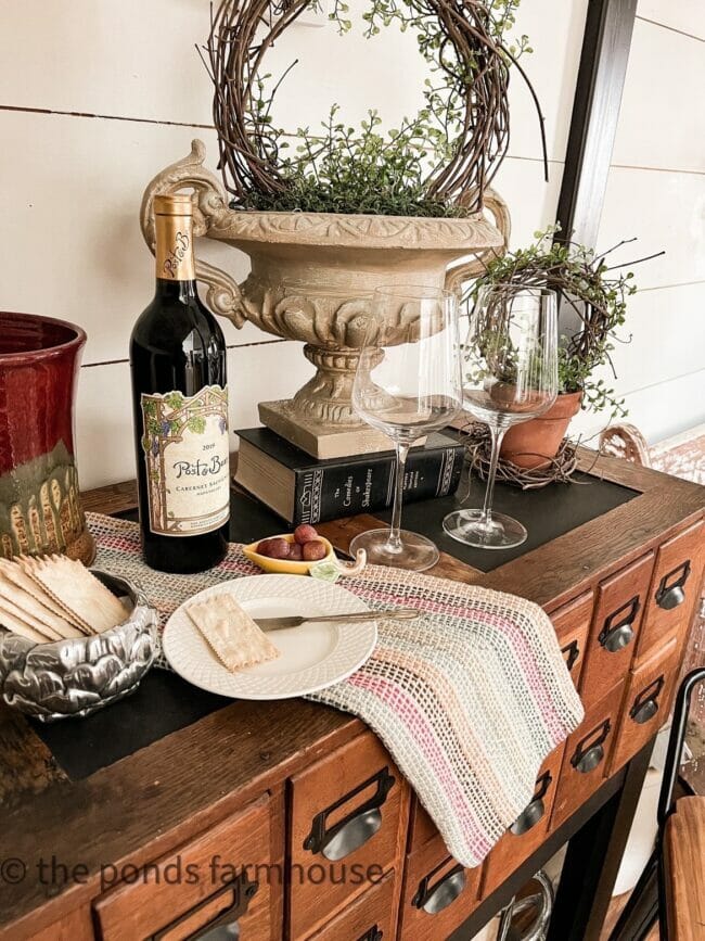 sideboard with wine, topiaries and place setting