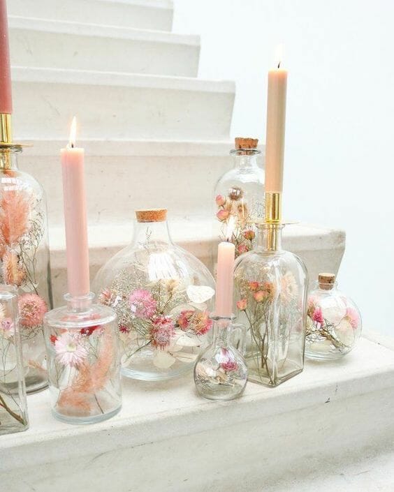 clear glass vases with flowers inside and candles