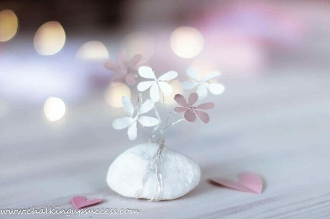 white rock with pink metal flowers wrapped around it