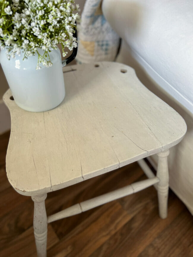 seat of broken chair with flowers used as a side table