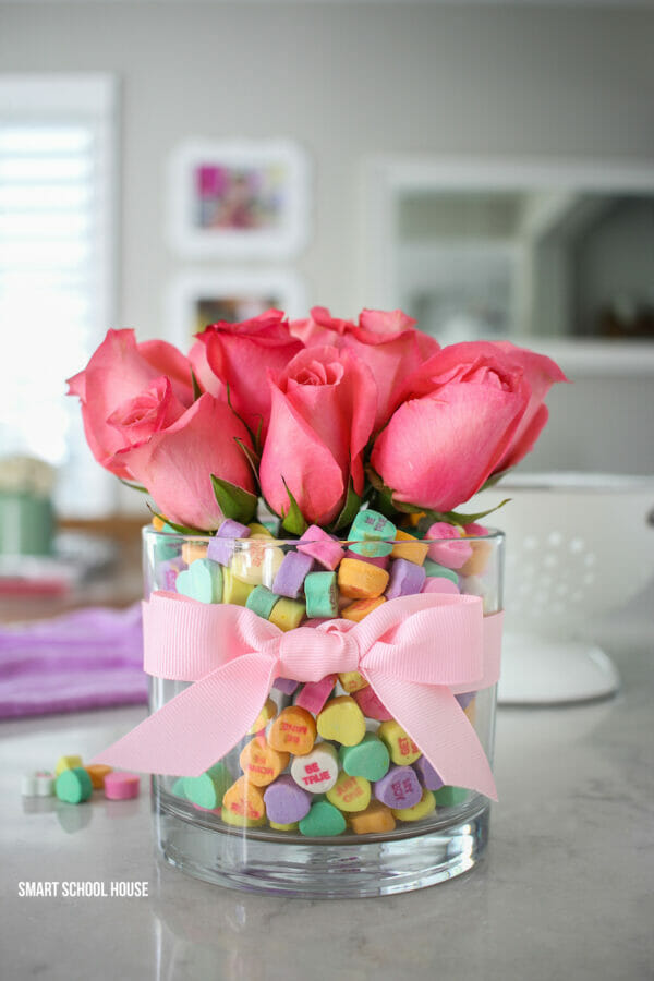 glass jar with heart candy and pink roses