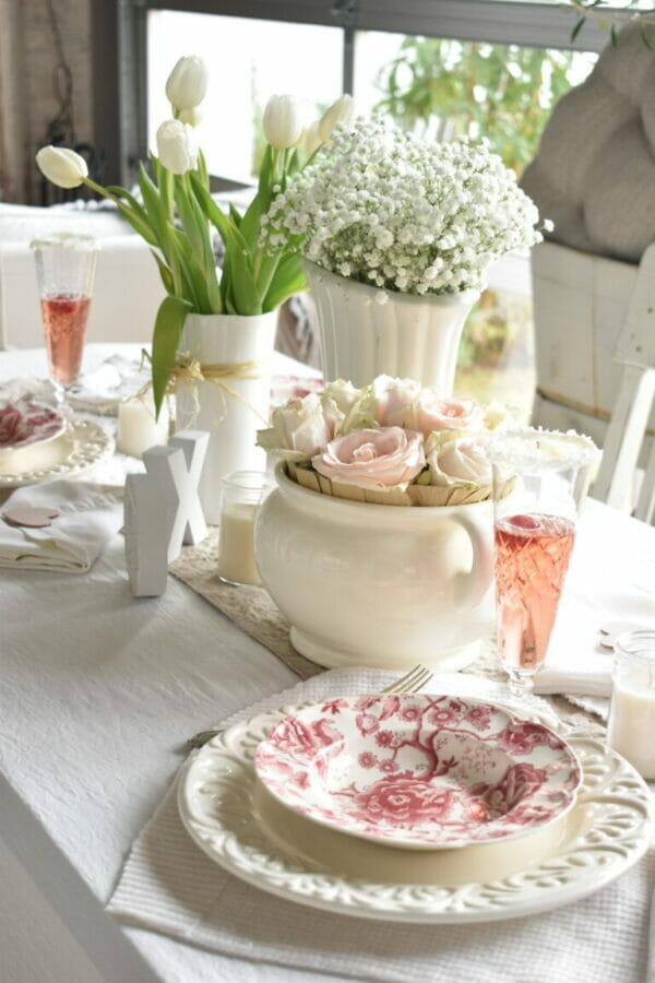 valentines day table setting with toile plates, pink champagne and flowers
