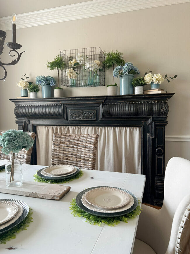 black mantel with blue and white hydrangeas and table setting