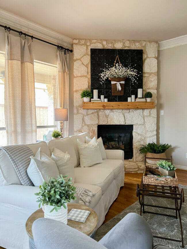 white sofa, mantel with black art and candles