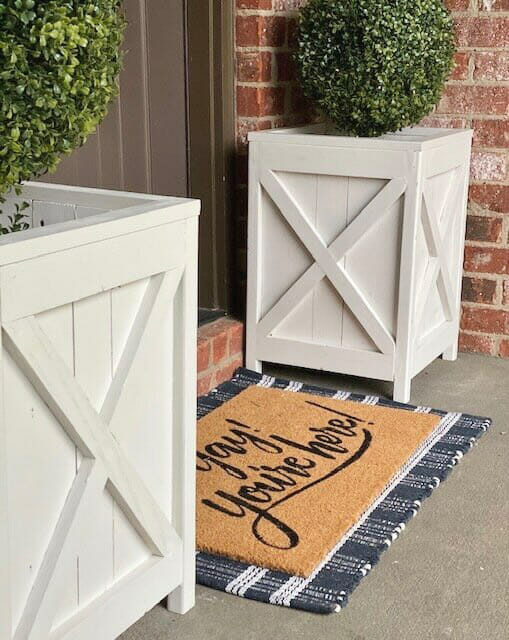 two white wood planter boxes with rug
