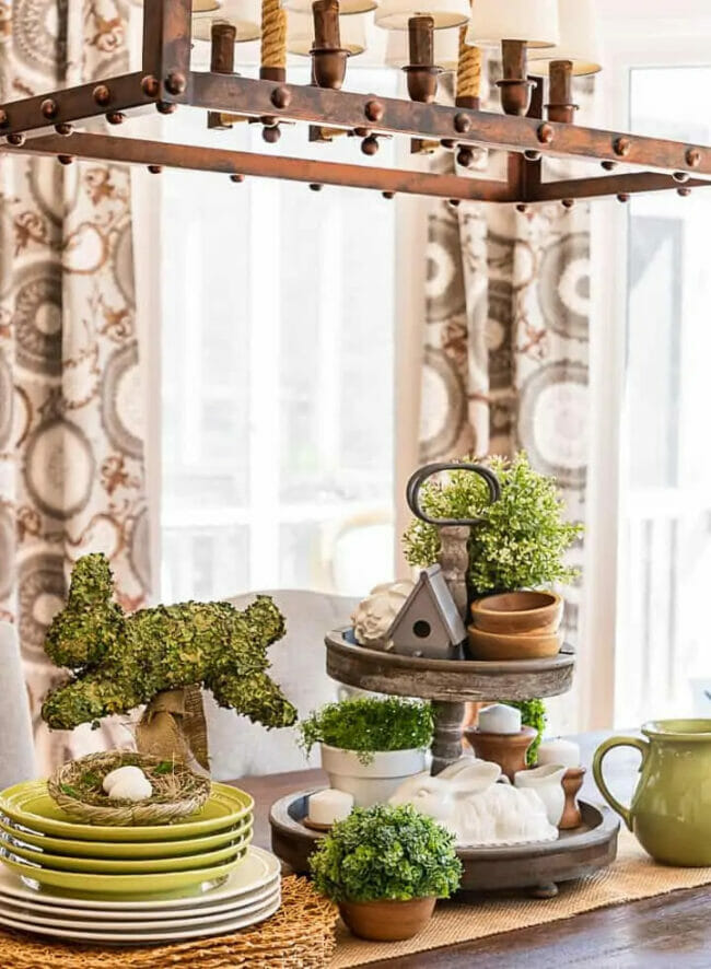 tablescape with green moss bunny, stack of plates and two tiered tray
