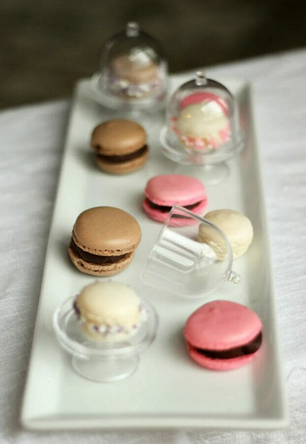 plate of pink and chocolate mini macarons.