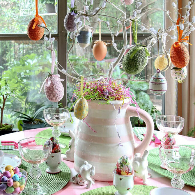 table with pitcher with egg branches and Easter table setting