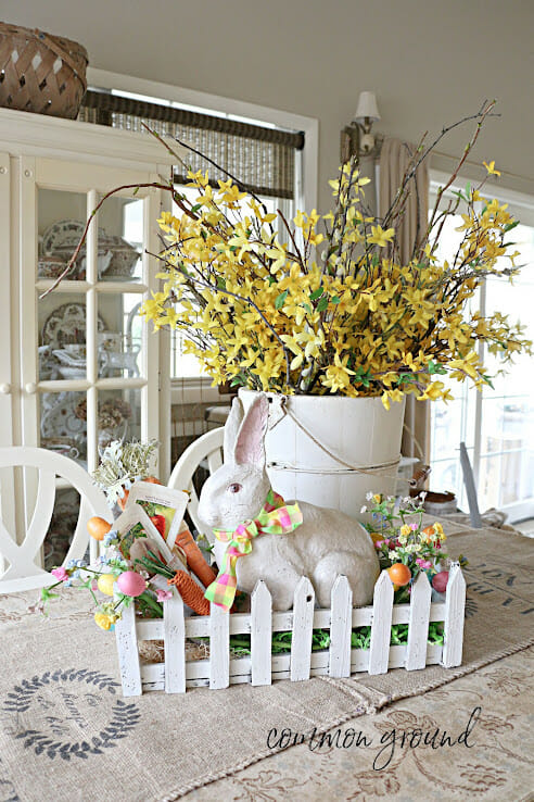 Easter centerpiece with white bunny, yellow flowers and carrots
