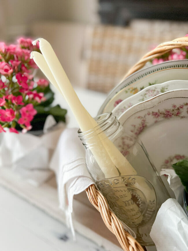 candles inside jar with potted flowers and plates