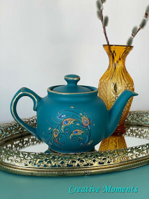 ble teapot with peacock decal on tray with gold vase