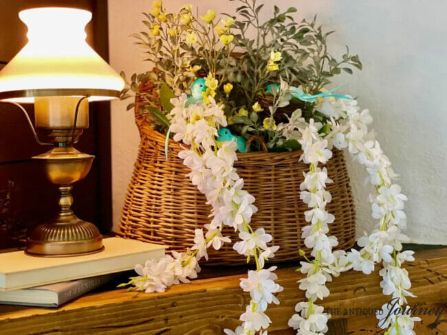 basket with flowers, blue birds sitting next to old lamp