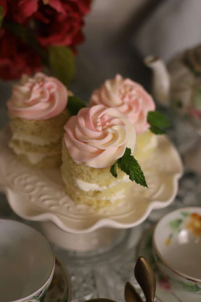 pink frosted cupcakes on white cake stand