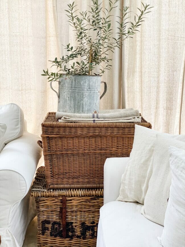 stack of wicker baskets with bucket and white sofas