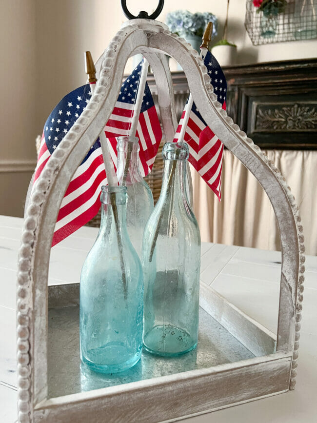 3 vintage blue jars with mini flags inside white beaded lantern for patriotic decor