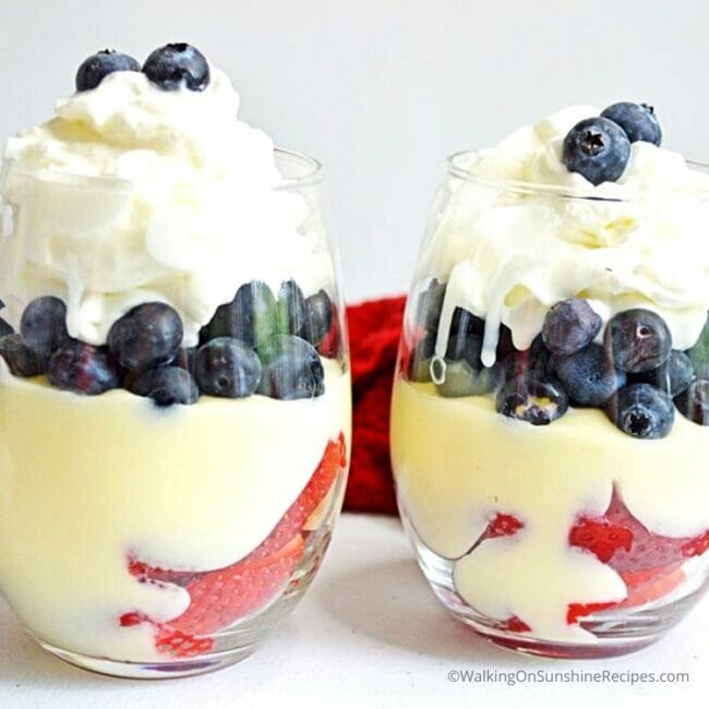 two glasses with pudding, berries and whipped topping