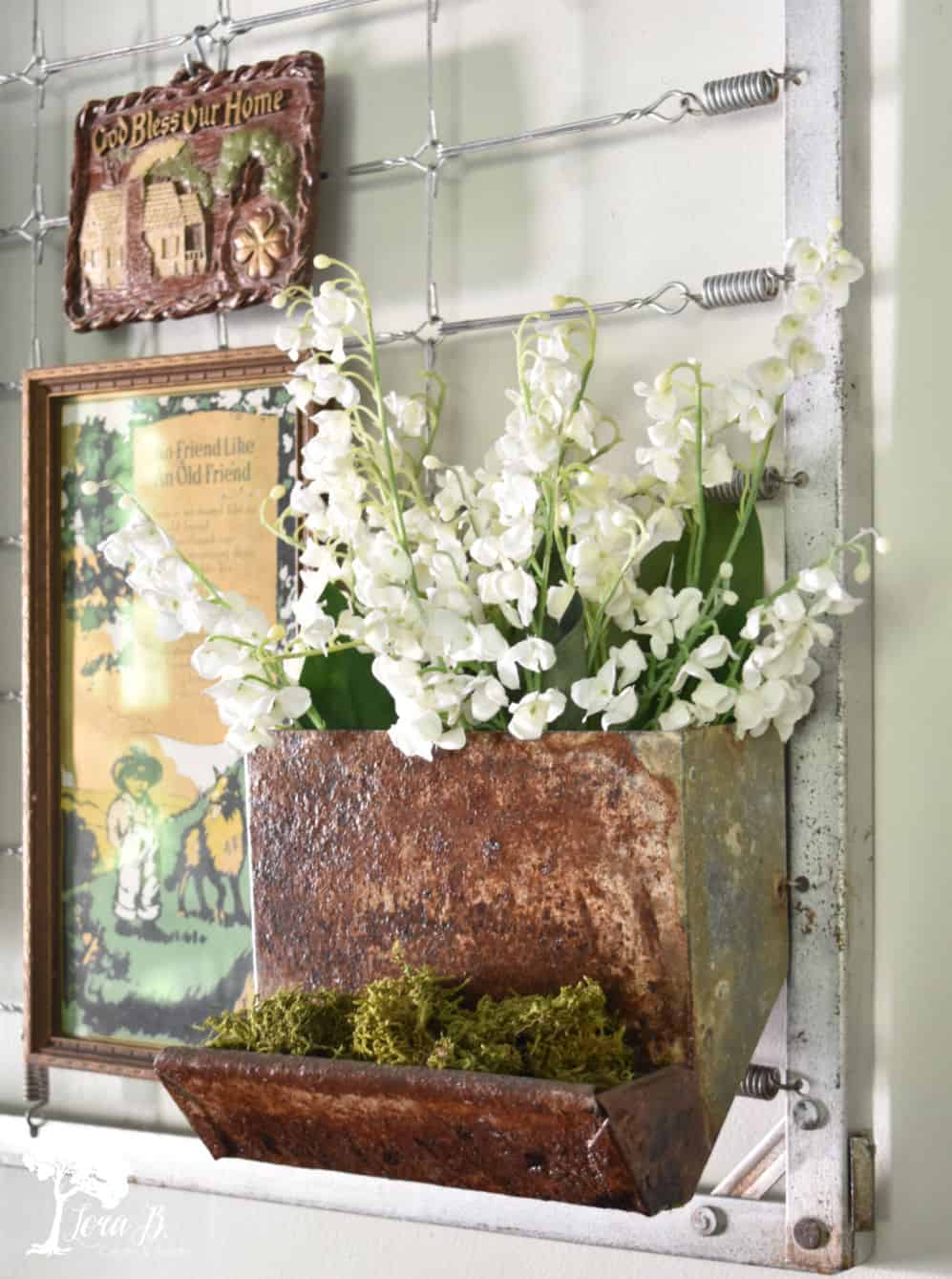 rusty container with white flowers and vintage sign