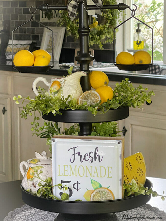 black tired tray with lemons, greenery and a fresh lemonade sign