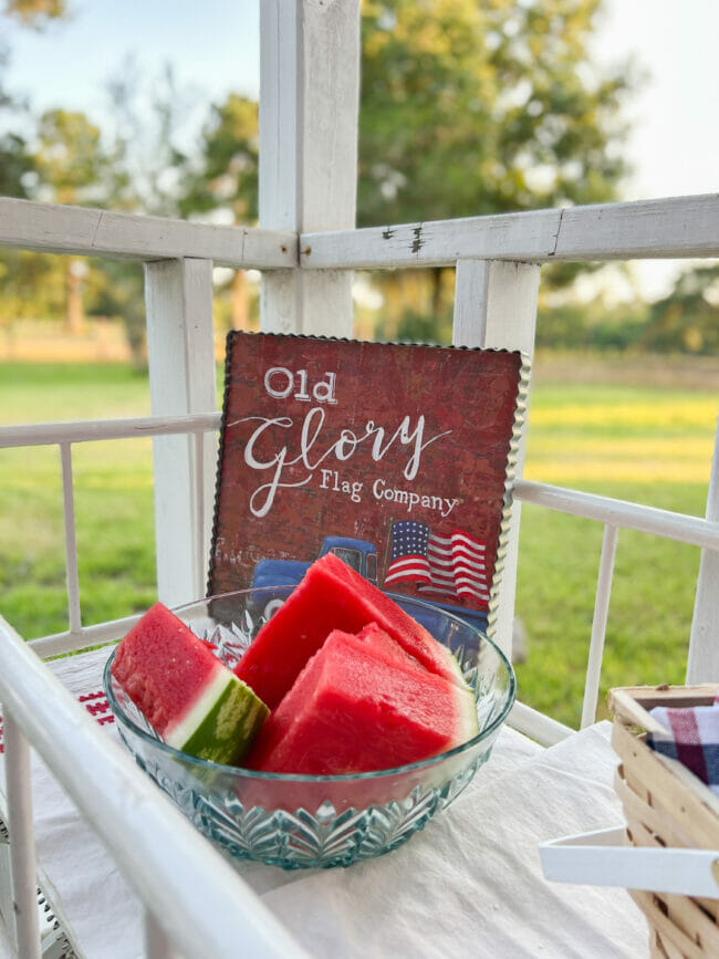 sliced watermelon with old glory sign in background