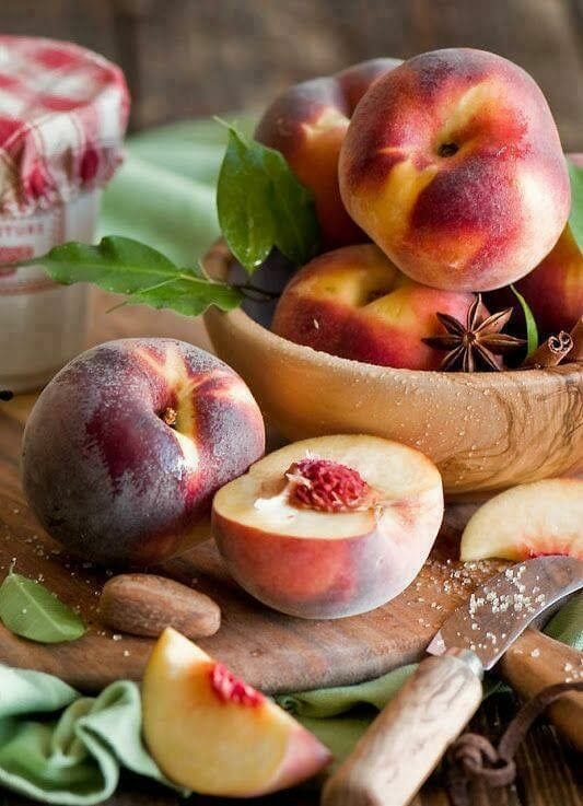 cut fresh peaches on wood board