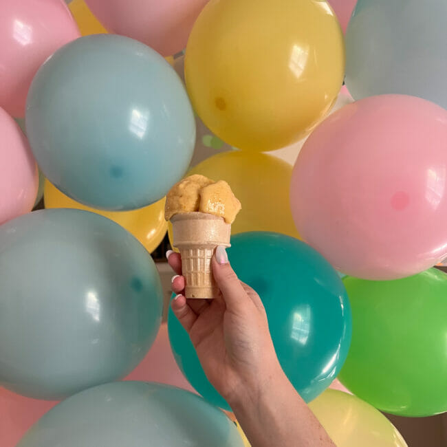 peach sherbet cone in front of balloons