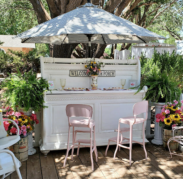 white bar with umbrella and pink barstools